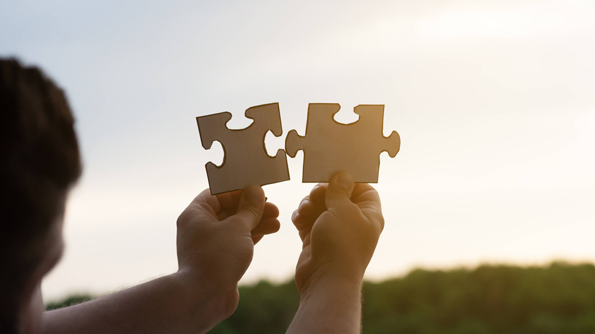 Zwei Puzzleteile werden zusammengehalten